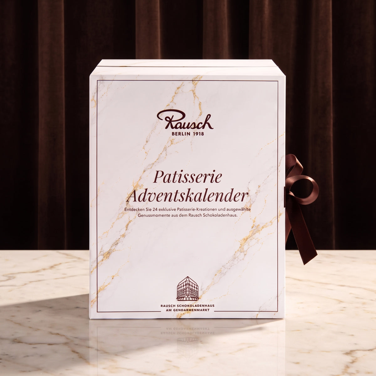 Eleganter weißer Adventskalender mit feiner Marmoroptik und brauner Schleife, handwerkliche Schokolade. - Rausch