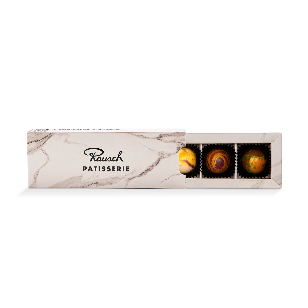 Edle handwerkliche Pralinen in schwarzer Box mit gold-gelben Marmorierungsspitzen. - Rausch