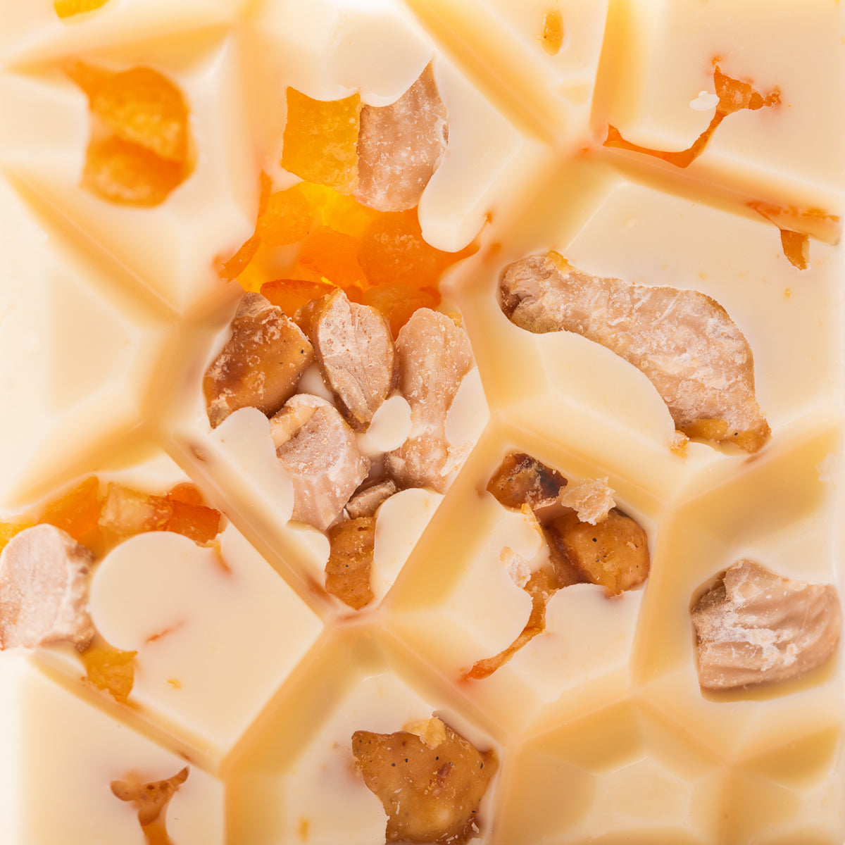 Weiße handwerkliche Schokolade mit Nüssen und getrockneten Früchten in geometrischem Muster. - Rausch