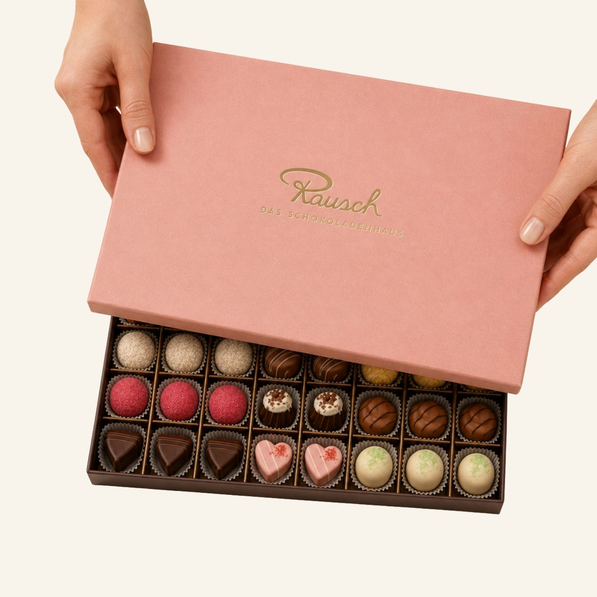 Rosa Premium-Schachtel mit 40 handwerklichen Pralinen in verschiedenen Farben und Formen. - Rausch