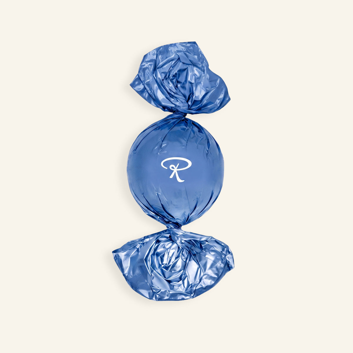 Handwerkliche dunkle Pralinenkugel in glänzend blauer Folie mit weißem „R“-Logo. - Rausch
