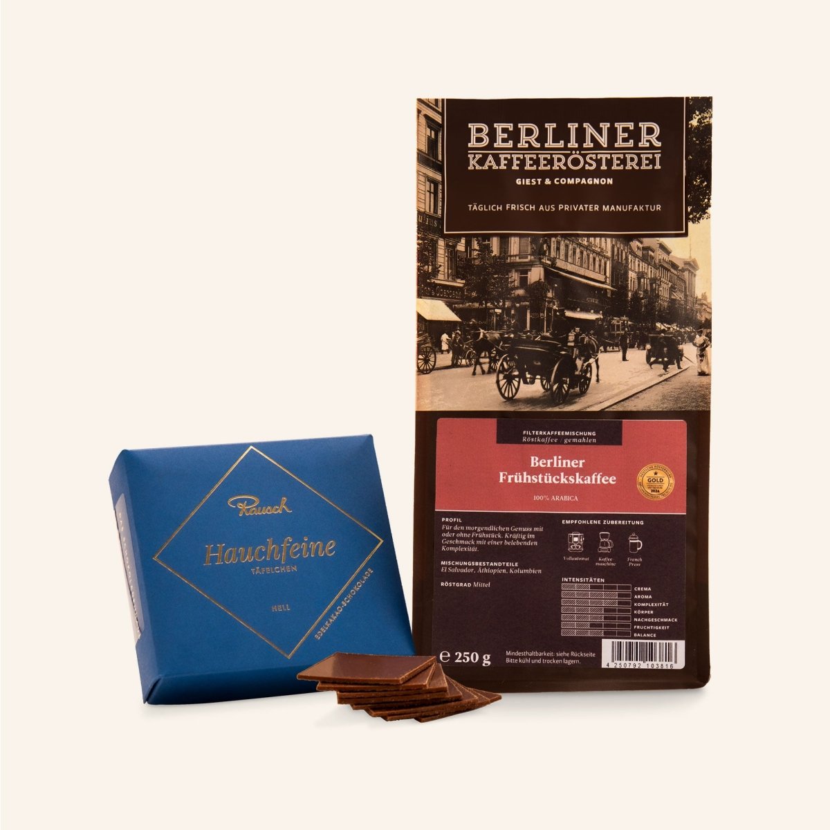 Eine Packung Kaffee der Berliner Kaffeerösterei und eine Schachtel Hauchfeine Täfelchen auf beigem Hintergrund.