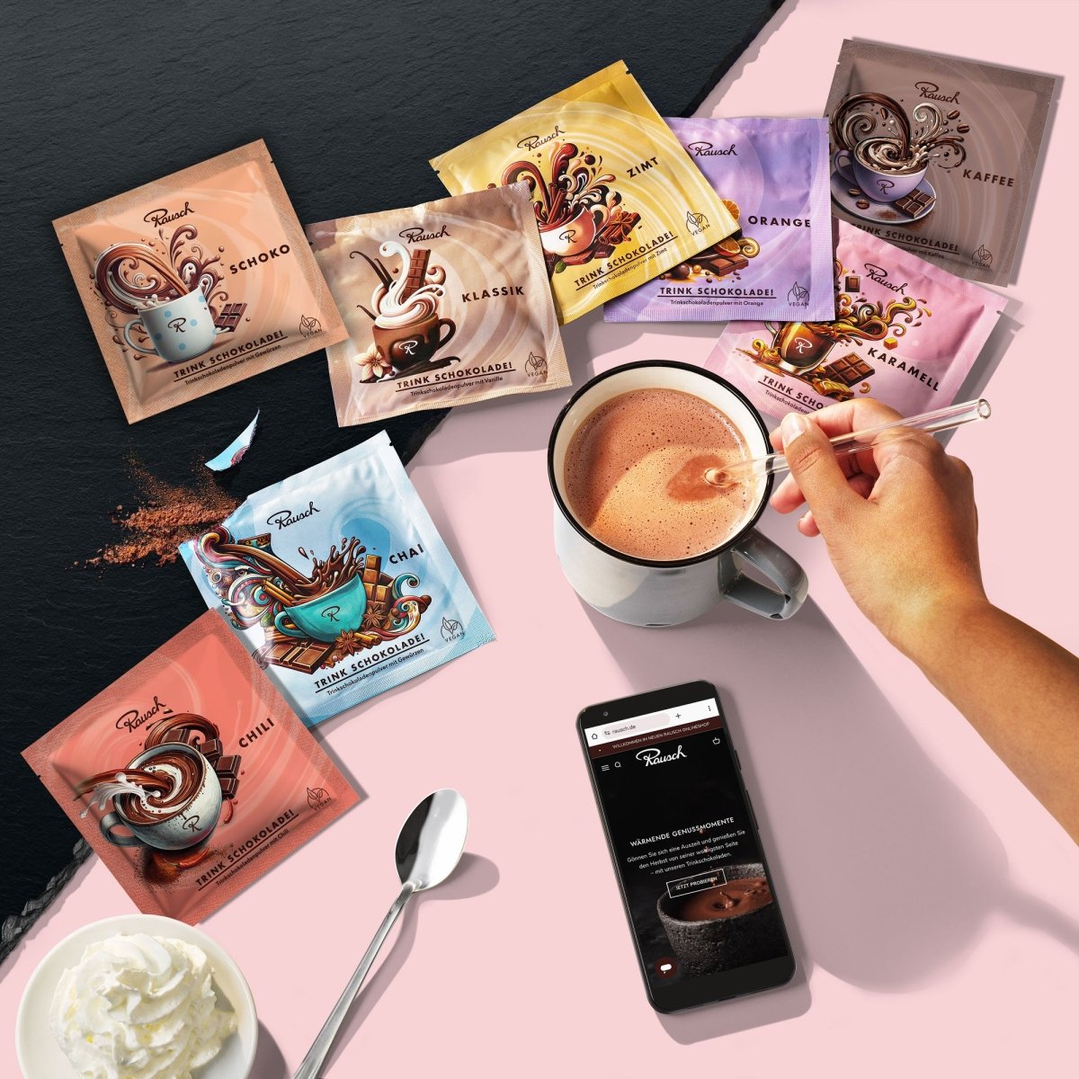 Acht Sorten Rausch Trinkschokolade in bunten Sachets, eine Hand rührt eine Tasse Schokolade um, daneben Smartphone, Sahne und Löffel.
